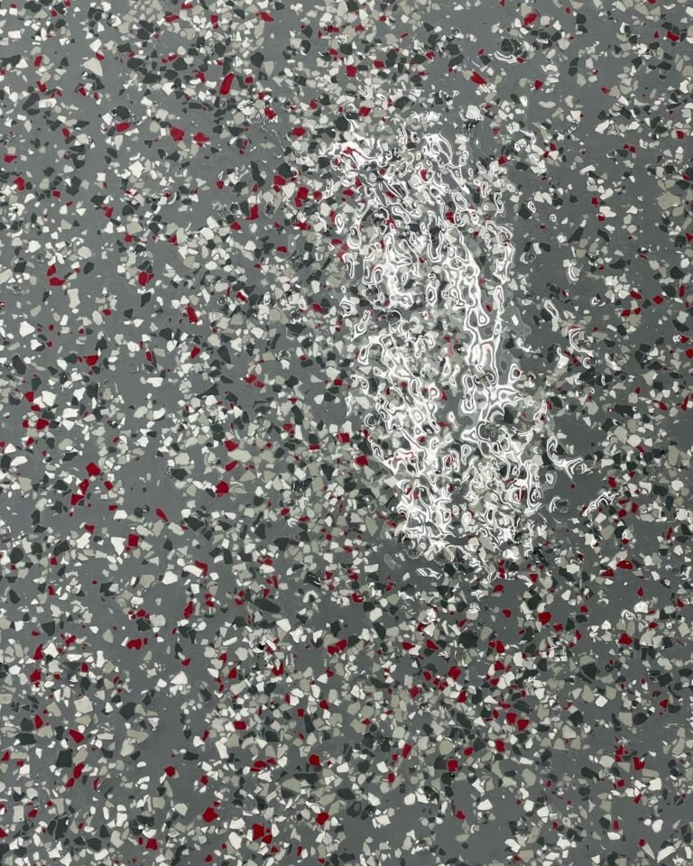 Epoxy floor featuring gravel flake blend with shades of grey, red, and dark green.